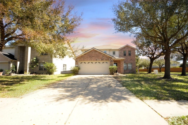 traditional-style home featuring a lawn, an attached garage, and concrete driveway