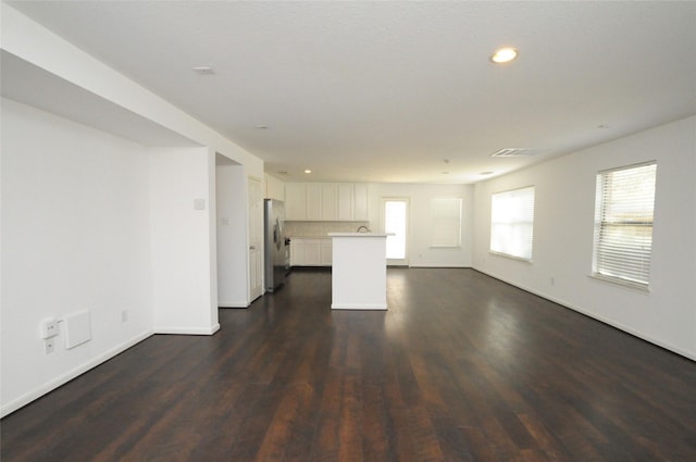 unfurnished living room with recessed lighting, visible vents, baseboards, and dark wood finished floors