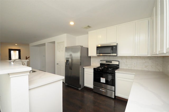 kitchen with white cabinetry, tasteful backsplash, visible vents, and stainless steel appliances