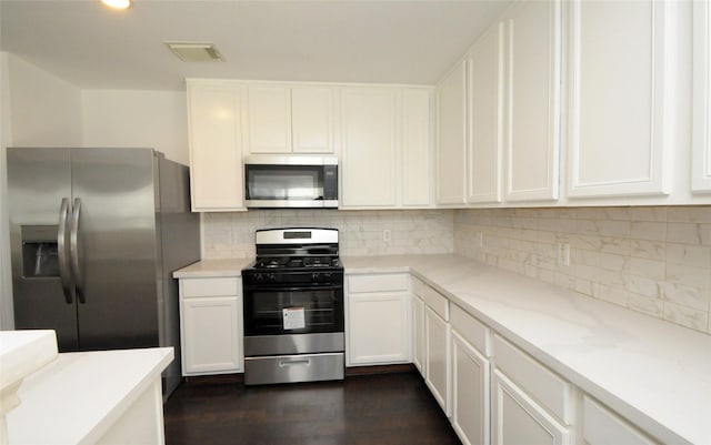 kitchen with light countertops, white cabinets, visible vents, and appliances with stainless steel finishes