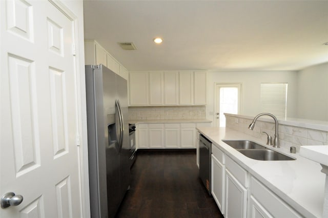 kitchen featuring tasteful backsplash, recessed lighting, stainless steel appliances, white cabinetry, and a sink