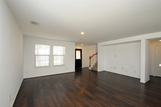 spare room featuring stairway, visible vents, baseboards, recessed lighting, and dark wood-type flooring