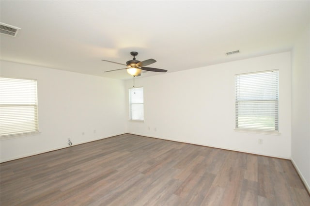 spare room featuring a ceiling fan, wood finished floors, and visible vents