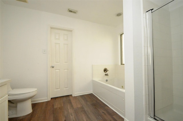 full bath with vanity, wood finished floors, visible vents, a garden tub, and toilet