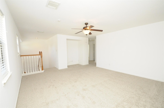 unfurnished room featuring light carpet, visible vents, and a ceiling fan