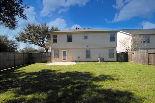 rear view of property featuring a lawn, central AC unit, a fenced backyard, and a patio area