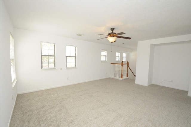 unfurnished room with visible vents, baseboards, and light colored carpet