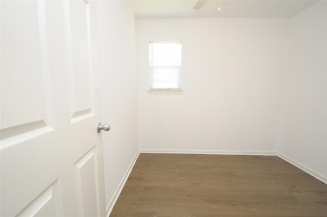 empty room featuring ceiling fan, dark wood-type flooring, and baseboards