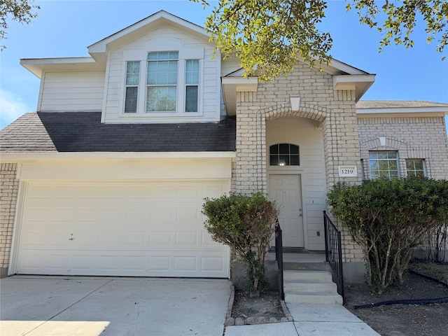 view of front of home with driveway, a shingled roof, and an attached garage