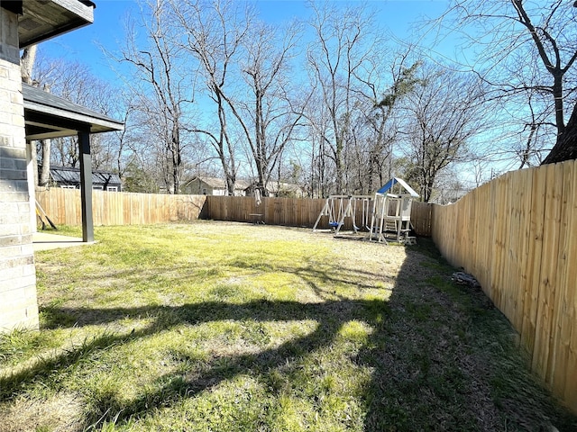 view of yard featuring a playground and a fenced backyard