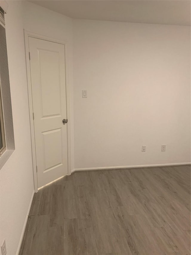 spare room with wood finished floors and baseboards