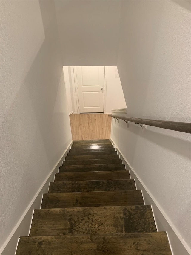 stairs featuring wood finished floors