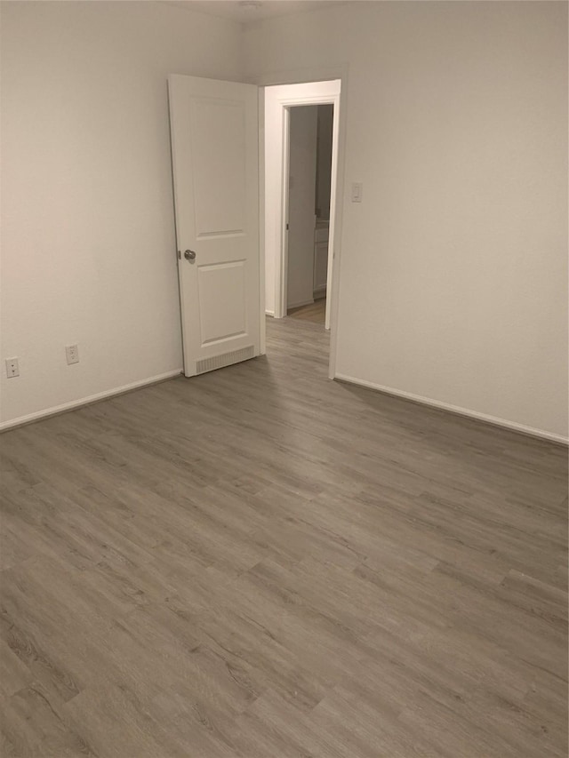 unfurnished room featuring baseboards and wood finished floors