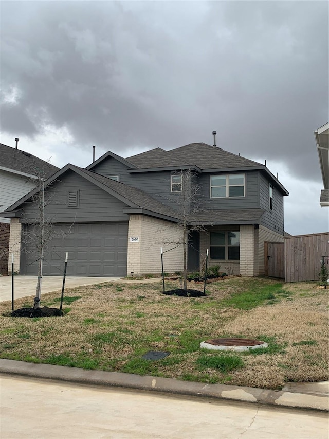 view of front of property with an attached garage, driveway, fence, and brick siding