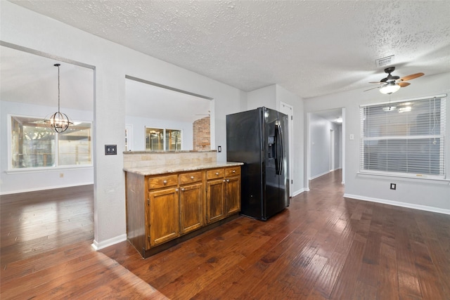 kitchen featuring visible vents, brown cabinets, black fridge with ice dispenser, a textured ceiling, and dark wood-style flooring