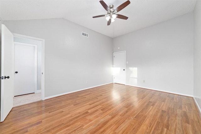 unfurnished room featuring a ceiling fan, visible vents, baseboards, lofted ceiling, and light wood-style flooring