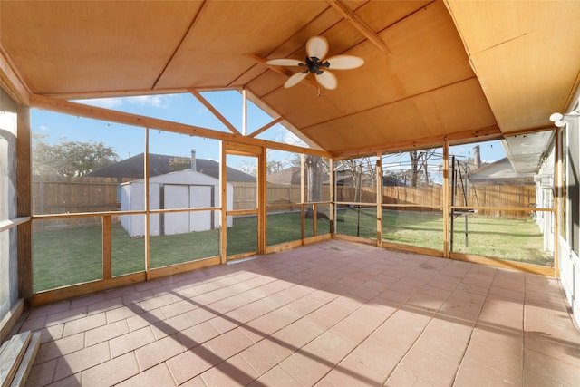 unfurnished sunroom with a healthy amount of sunlight, wooden ceiling, a ceiling fan, and vaulted ceiling