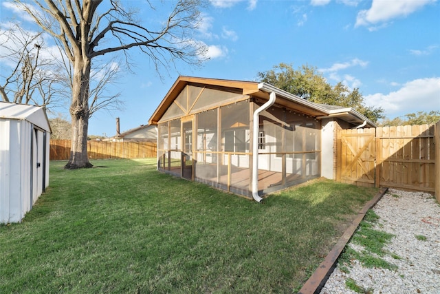 exterior space featuring an outbuilding, a storage shed, a fenced backyard, and a sunroom