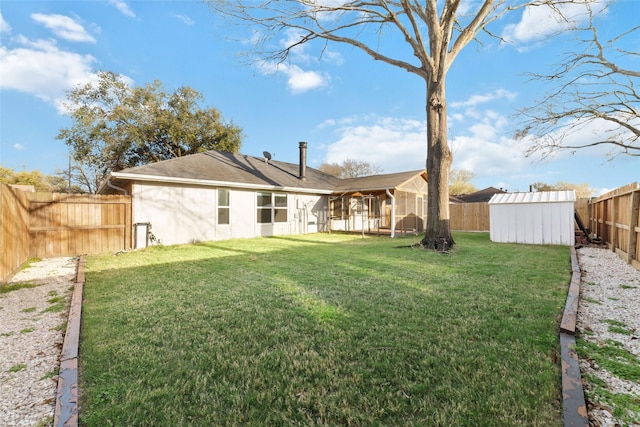 back of property featuring a lawn, stucco siding, an outdoor structure, a fenced backyard, and a storage unit