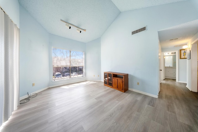 unfurnished room with baseboards, visible vents, a textured ceiling, and wood finished floors