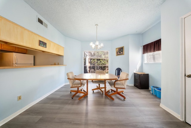 dining room with baseboards, a textured ceiling, visible vents, and dark wood-type flooring