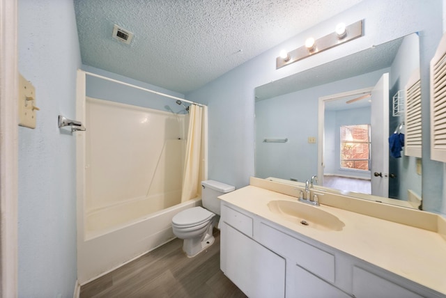 bathroom with visible vents, toilet, wood finished floors, a textured ceiling, and vanity