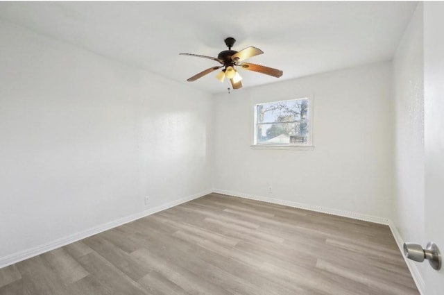 empty room featuring wood finished floors, a ceiling fan, and baseboards