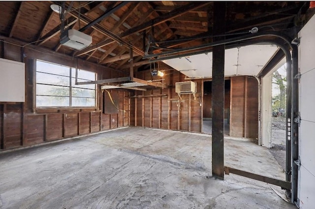 garage with a garage door opener and an AC wall unit