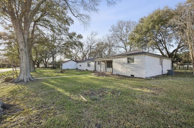 view of front facade with central AC unit, crawl space, a front yard, and brick siding