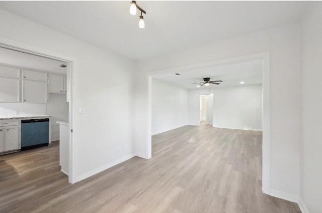 spare room with light wood-type flooring, ceiling fan, and baseboards