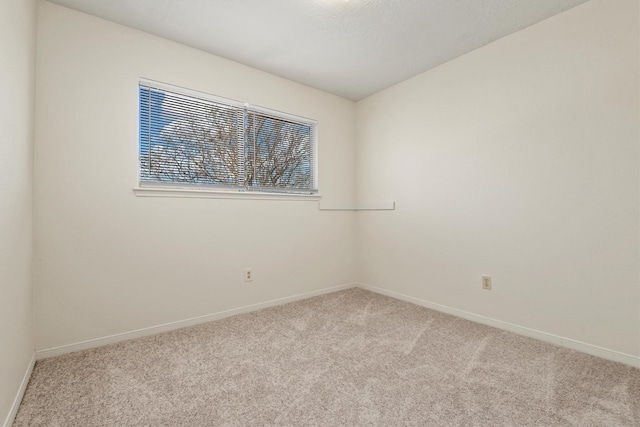 unfurnished room with baseboards and carpet flooring