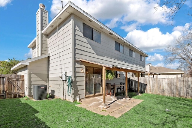 back of property featuring a patio area, a lawn, a chimney, and central air condition unit