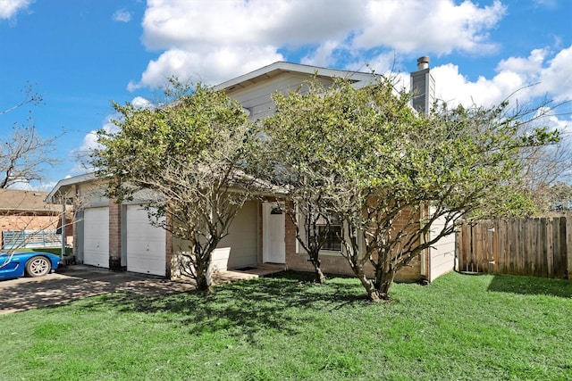 obstructed view of property featuring brick siding, concrete driveway, an attached garage, a front yard, and fence