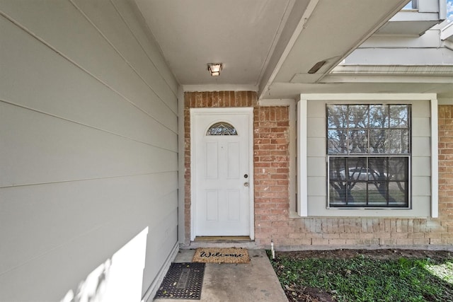 doorway to property with brick siding