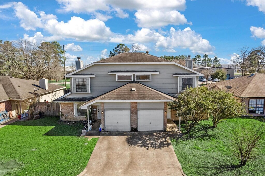 10033 Emerald Creek Dr, Houston, TX 77070 - traditional home featuring a front yard, driveway, a chimney, and brick siding