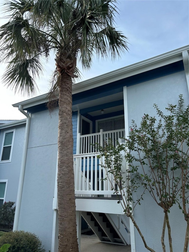 view of side of home with stairway and stucco siding