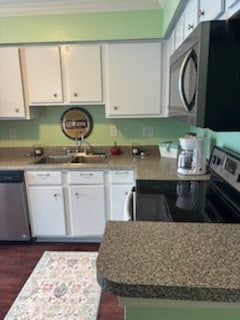 3506 Cove View Blvd Unit 1506, Galveston, TX 77554 - kitchen with a sink, white cabinets, stainless steel appliances, and dark wood finished floors