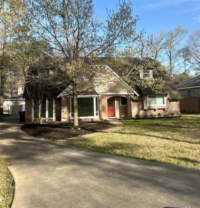 view of front facade with a garage, brick siding, an outdoor structure, and a front lawn