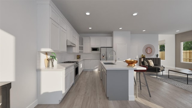 kitchen with stainless steel appliances, light countertops, a sink, and under cabinet range hood