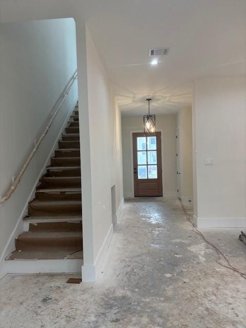 entryway with visible vents, an inviting chandelier, stairs, and baseboards