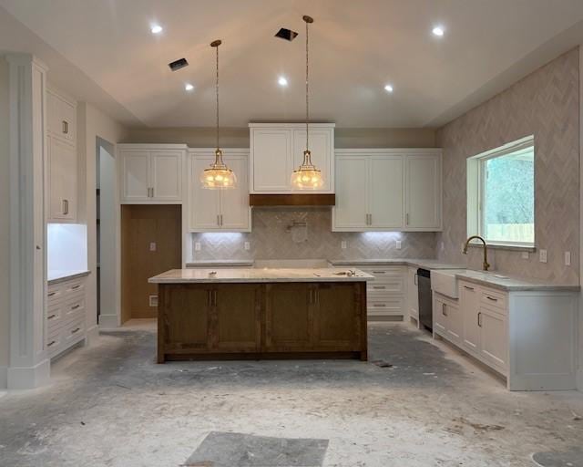 kitchen with a center island, lofted ceiling, stainless steel dishwasher, white cabinetry, and a sink