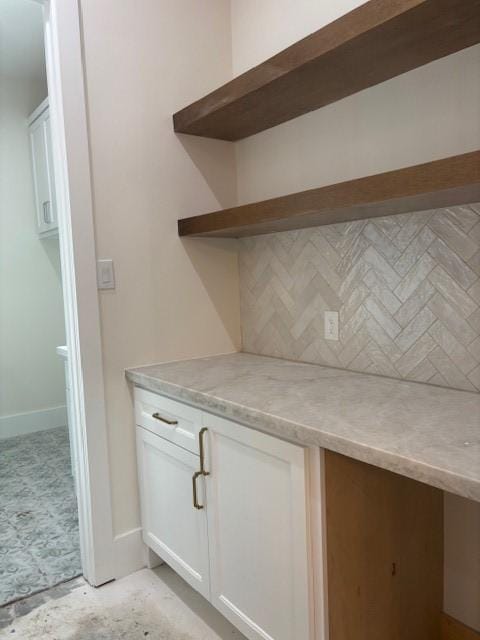 interior space featuring baseboards and decorative backsplash