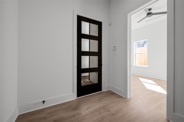 entryway with ceiling fan, baseboards, and wood finished floors