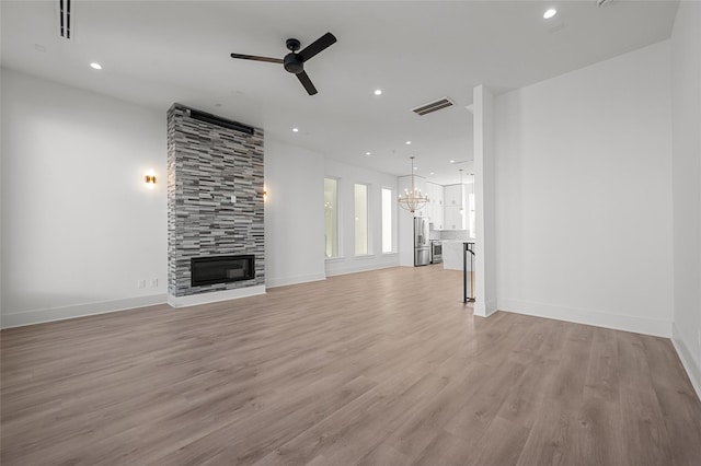 unfurnished living room with recessed lighting, ceiling fan with notable chandelier, visible vents, light wood-type flooring, and a tile fireplace