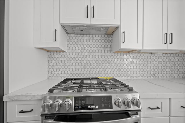 kitchen featuring light stone counters, decorative backsplash, white cabinetry, under cabinet range hood, and stainless steel gas range oven