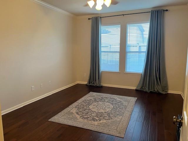 empty room with ceiling fan, crown molding, baseboards, and wood finished floors