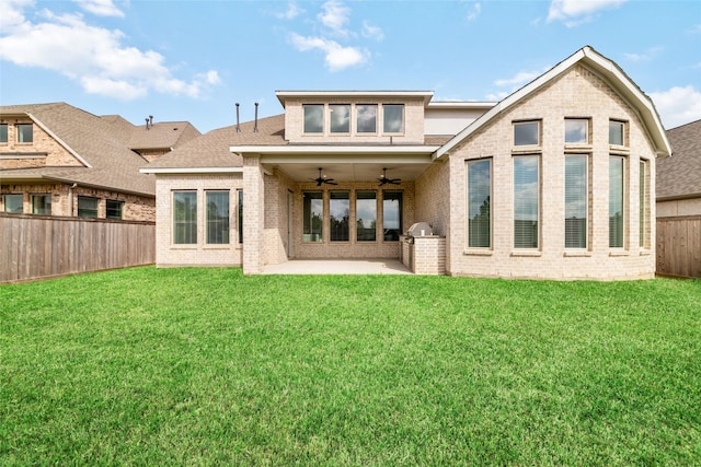 rear view of property featuring a fenced backyard, a ceiling fan, a lawn, and brick siding