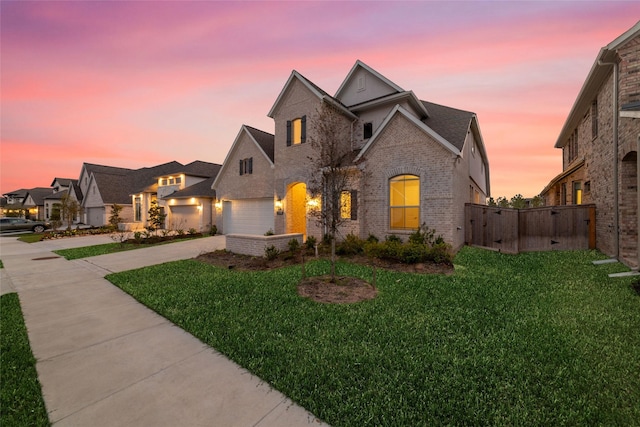 view of front of property with driveway, a yard, a gate, and brick siding