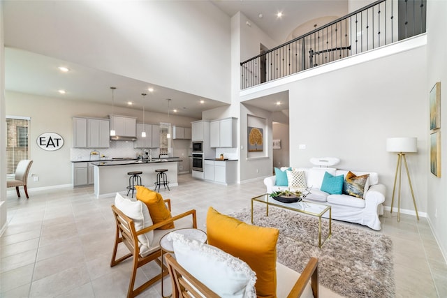 living area with light tile patterned floors, baseboards, and recessed lighting