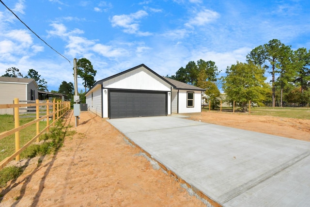 view of front of home featuring concrete driveway, an attached garage, and fence